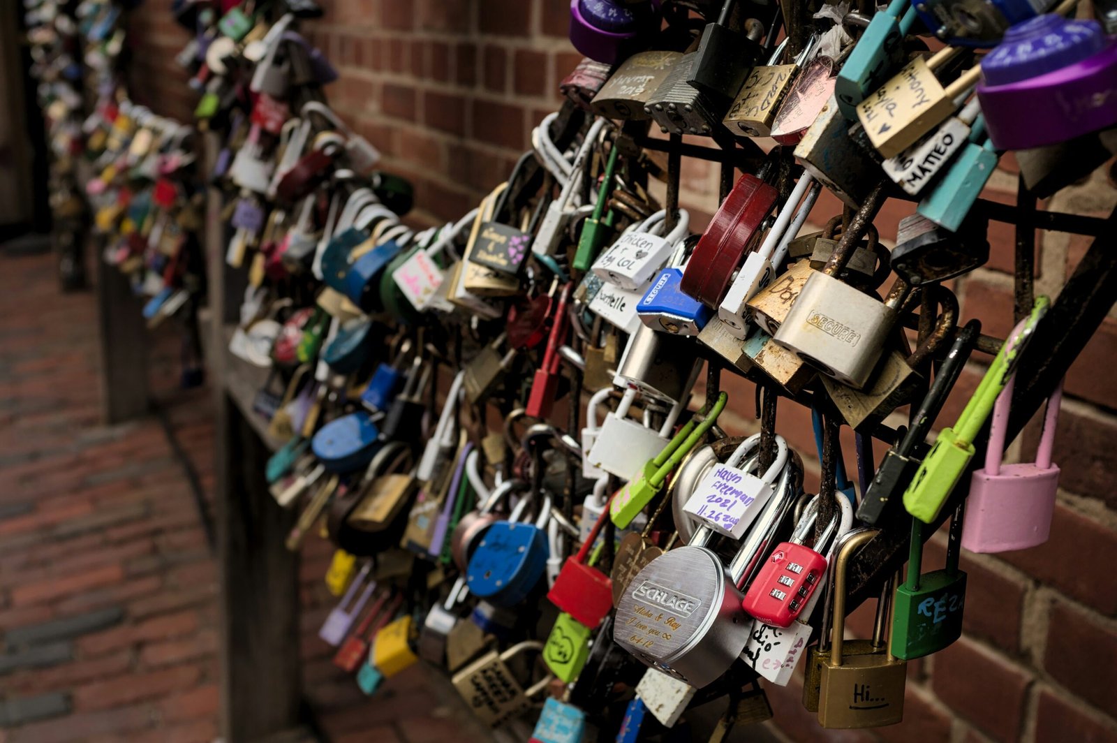 a bunch of padlocks attached to a fence