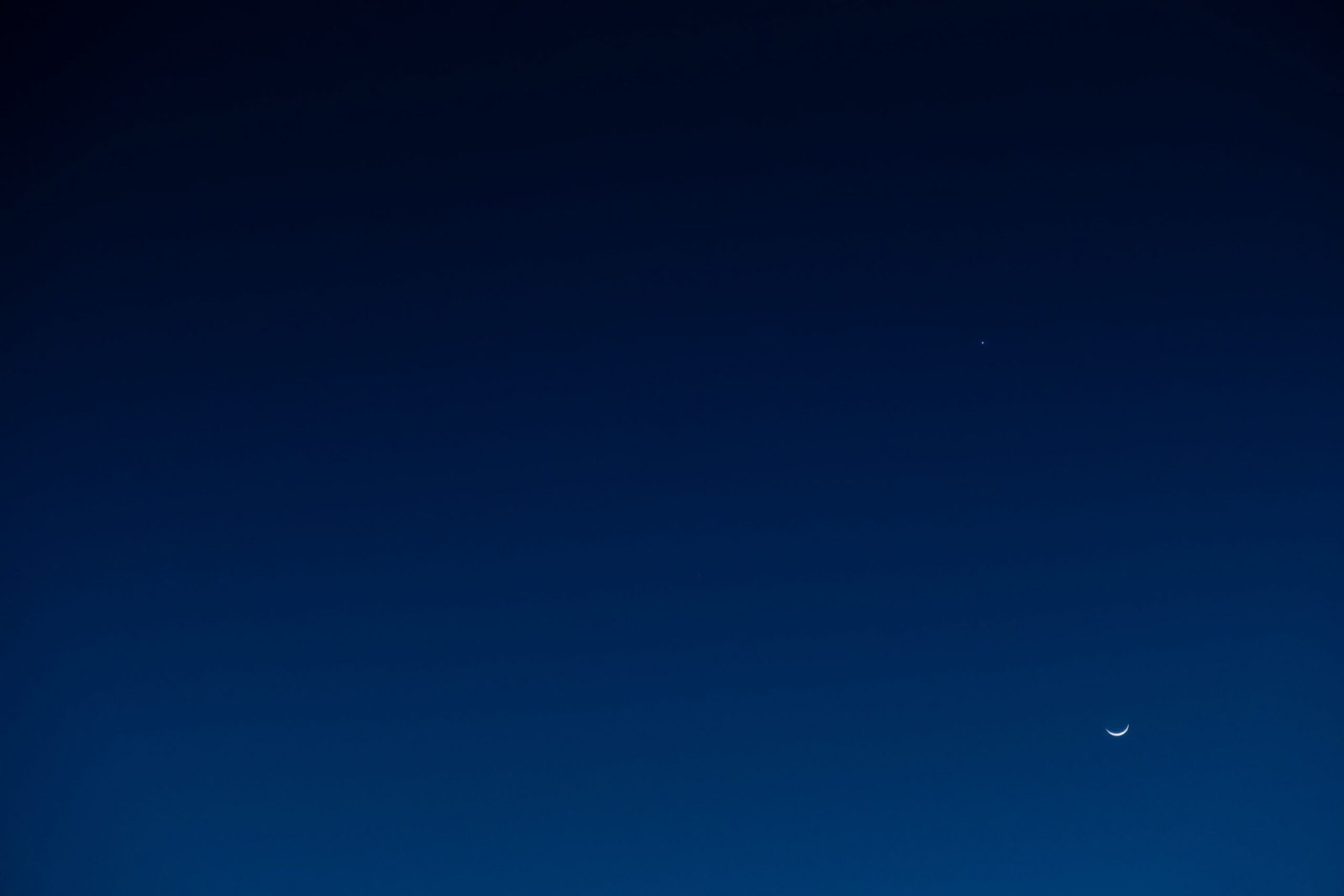 a plane flying in the sky with a moon in the background